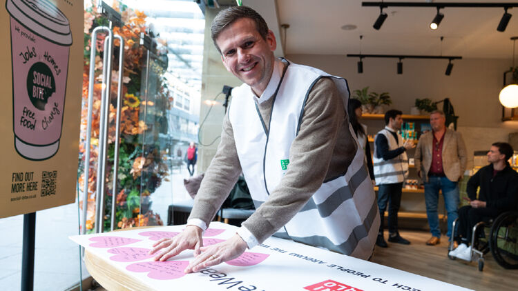 Een afbeelding van Gordon Reid die een hartvormige sticker opplakt.