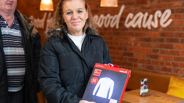 Een afbeelding van een vrouw die poseert met (of een HEATTECH-item vasthoudt.