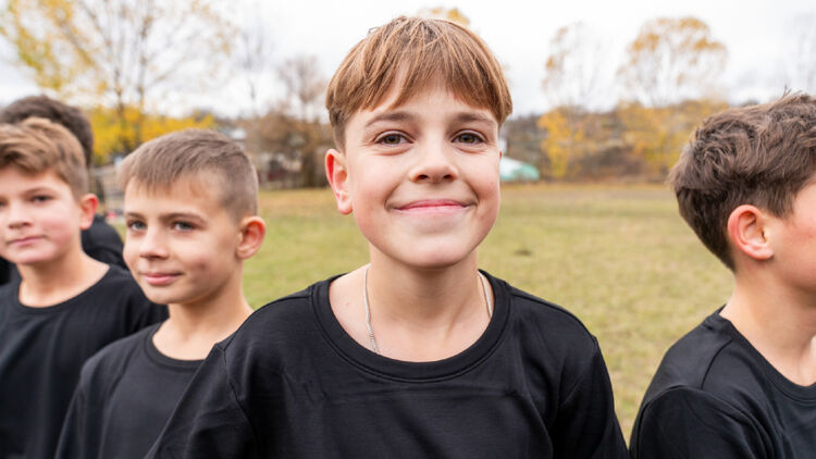 Afbeelding van een voetbaljongen die lachend poseert