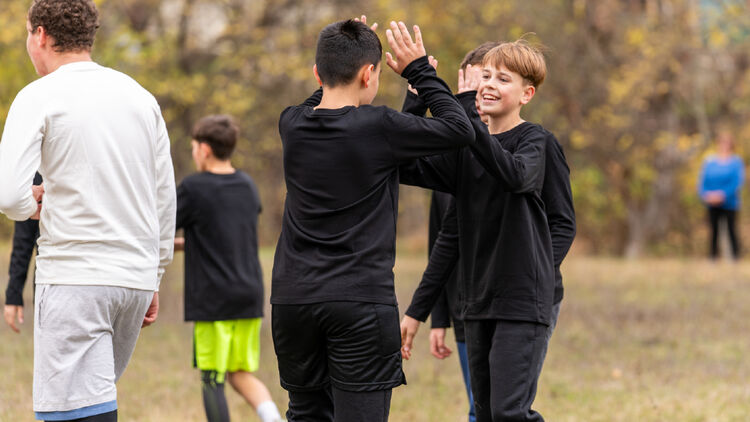 Afbeelding van twee kinderen die elkaar een high-five geven.