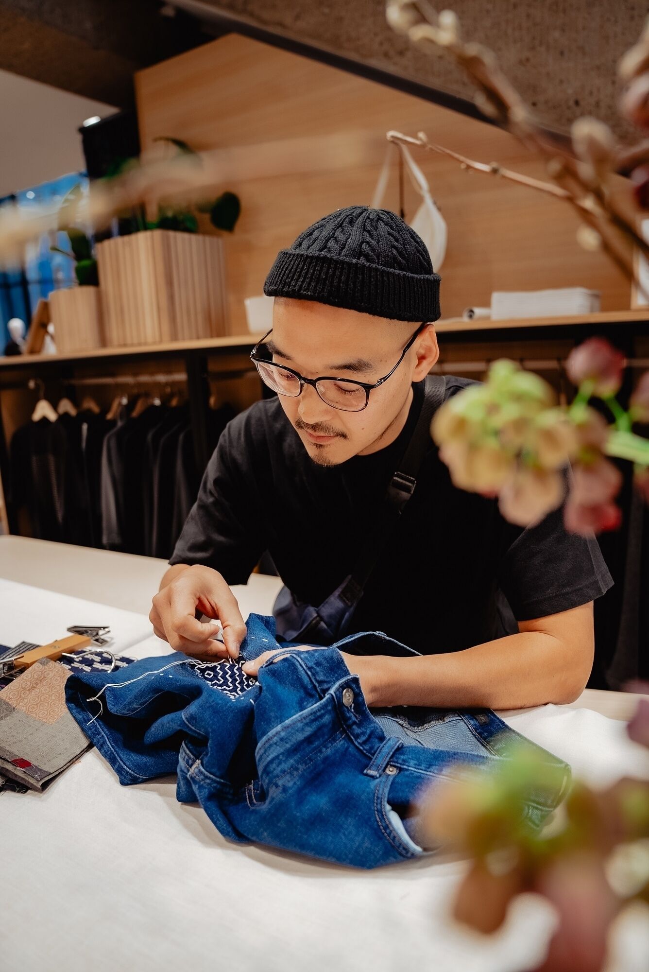 man stikt sashiko techniek op een jeans