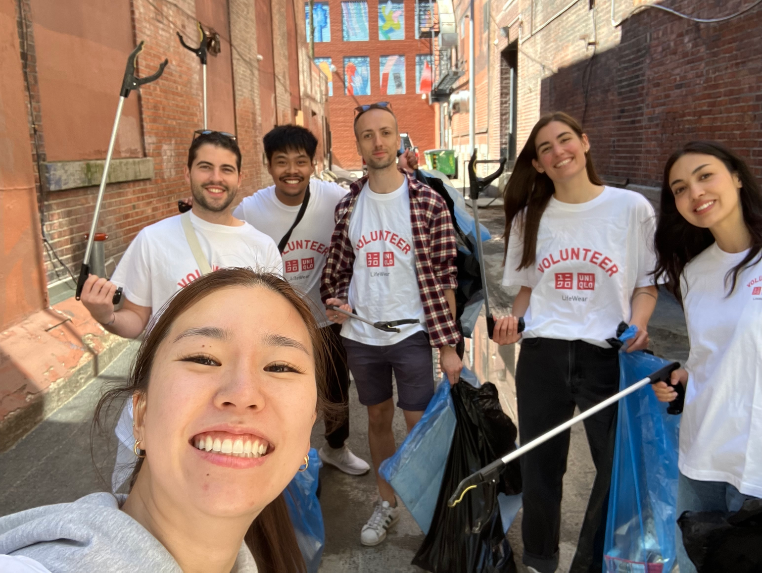 L’équipe québécoise d’UNIQLO Canada en pleine corvée de nettoyage dans les ruelles à proximité du square Dorchester, à Montréal. 