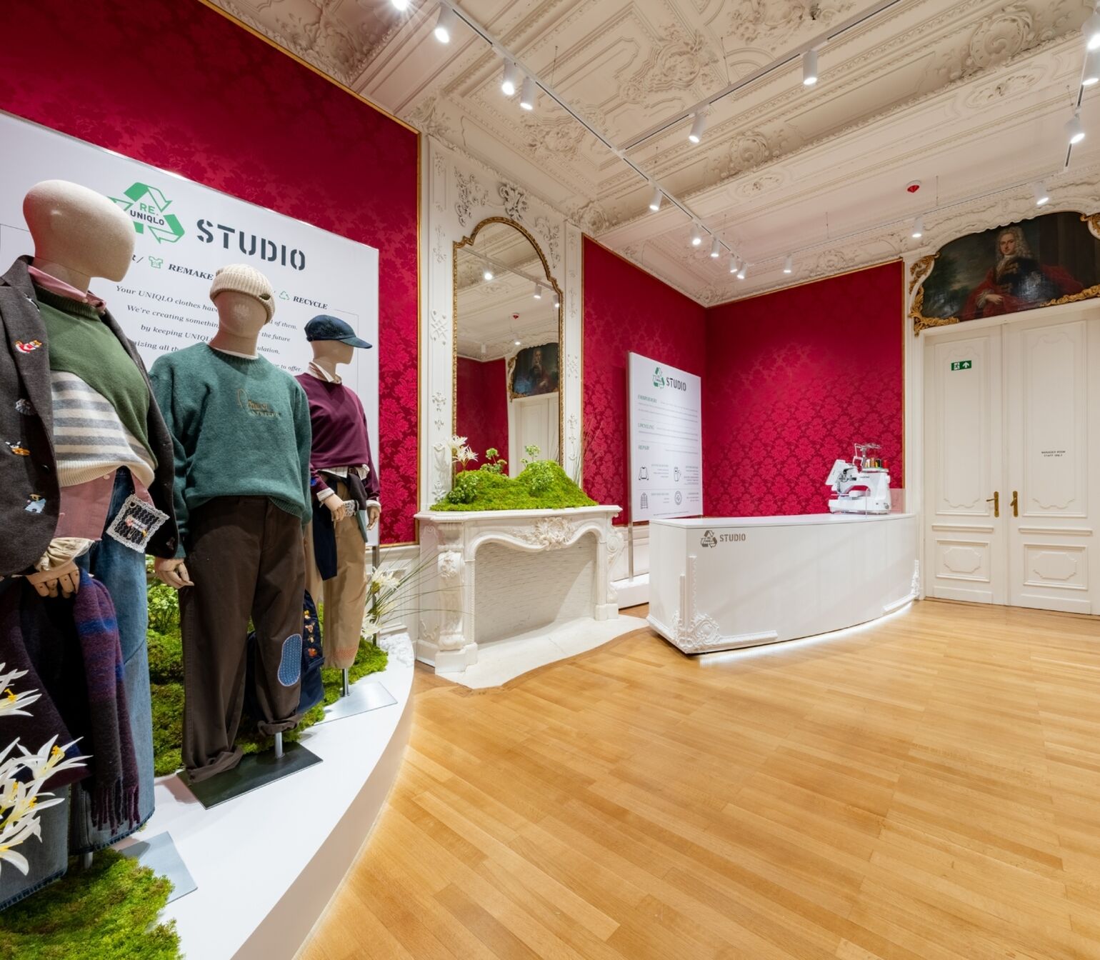 Photo of a room with three mannequins on one side and a mirror in the center