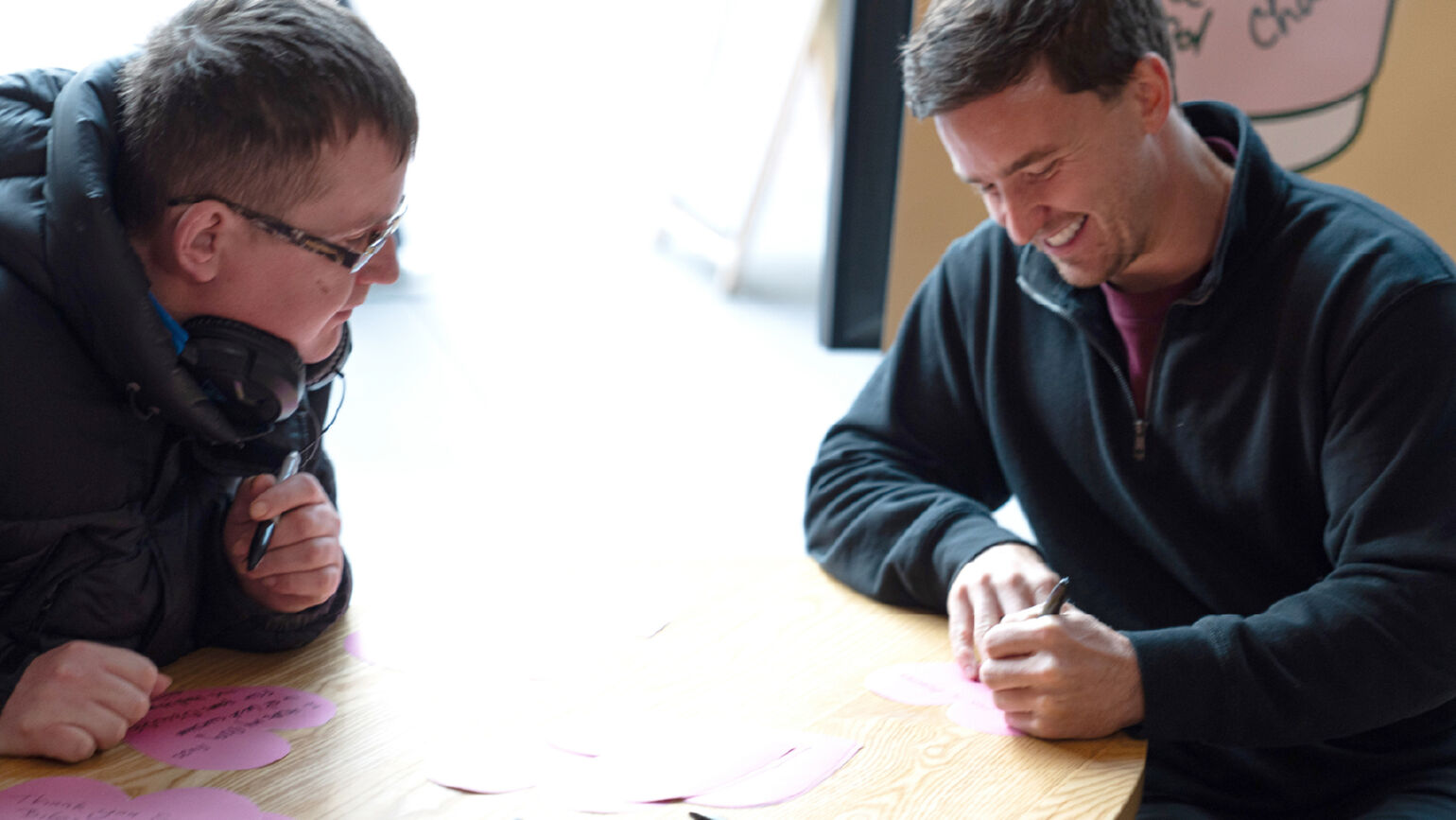 An image of Gordon Reid smiling and writing a message.