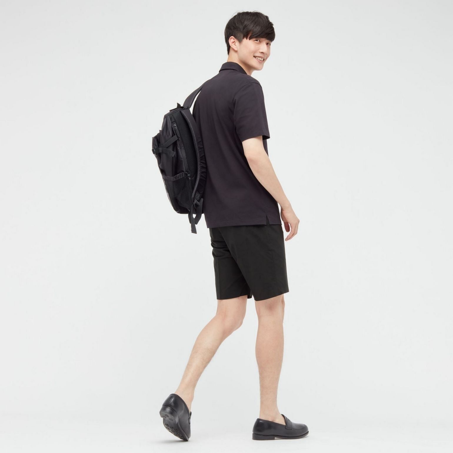 Mann mit Poloshirt schwarz und Shorts