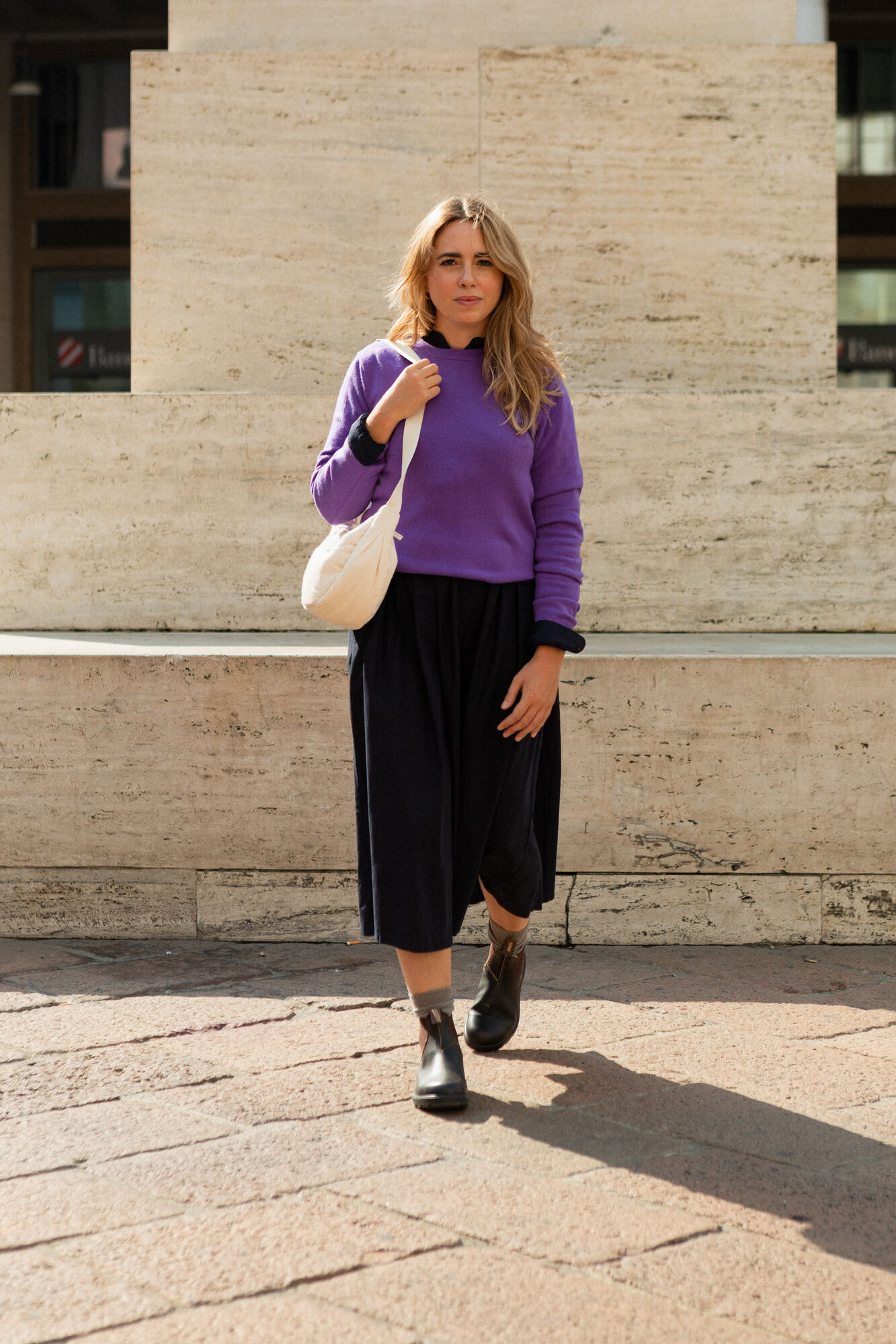 Model trägt lilafarbenen Kaschmirpullover und schwarzen Rock