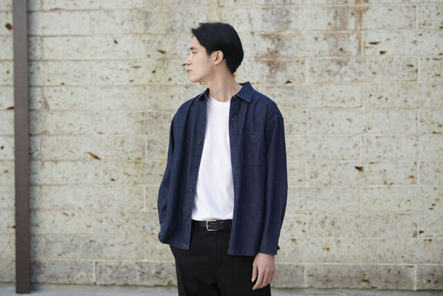 man wearing UNIQLO denim shirt, white T-shirt and black trousers