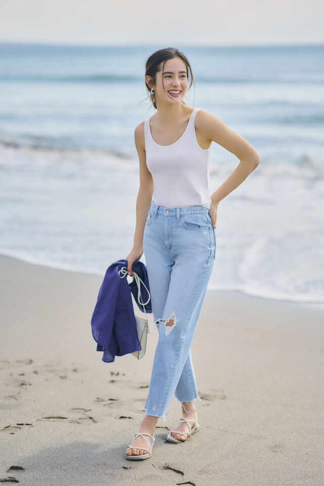 woman at the beach wearing UNIQLO tank top and jeans