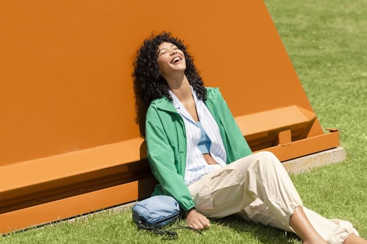 Female model wearing UV protection parka, a linen blend shirt, a bra top, and cargo trousers