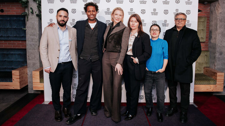An image of Cate Blanchett and other representatives standing shoulder to shoulder in front of a backdrop lined with logos.