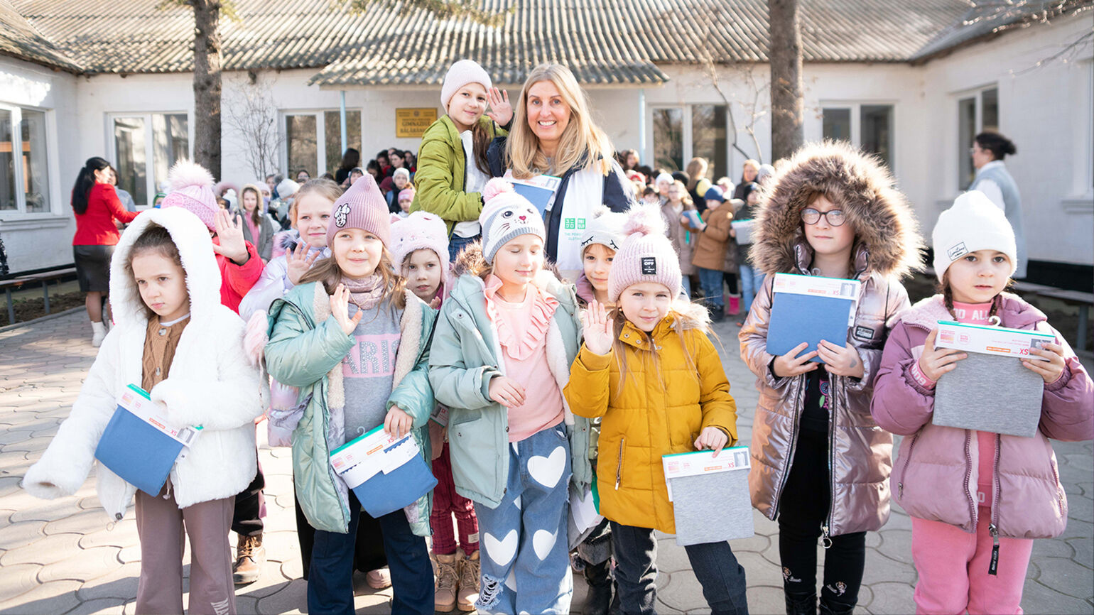 children holding HEATTECH thermal clothing donations