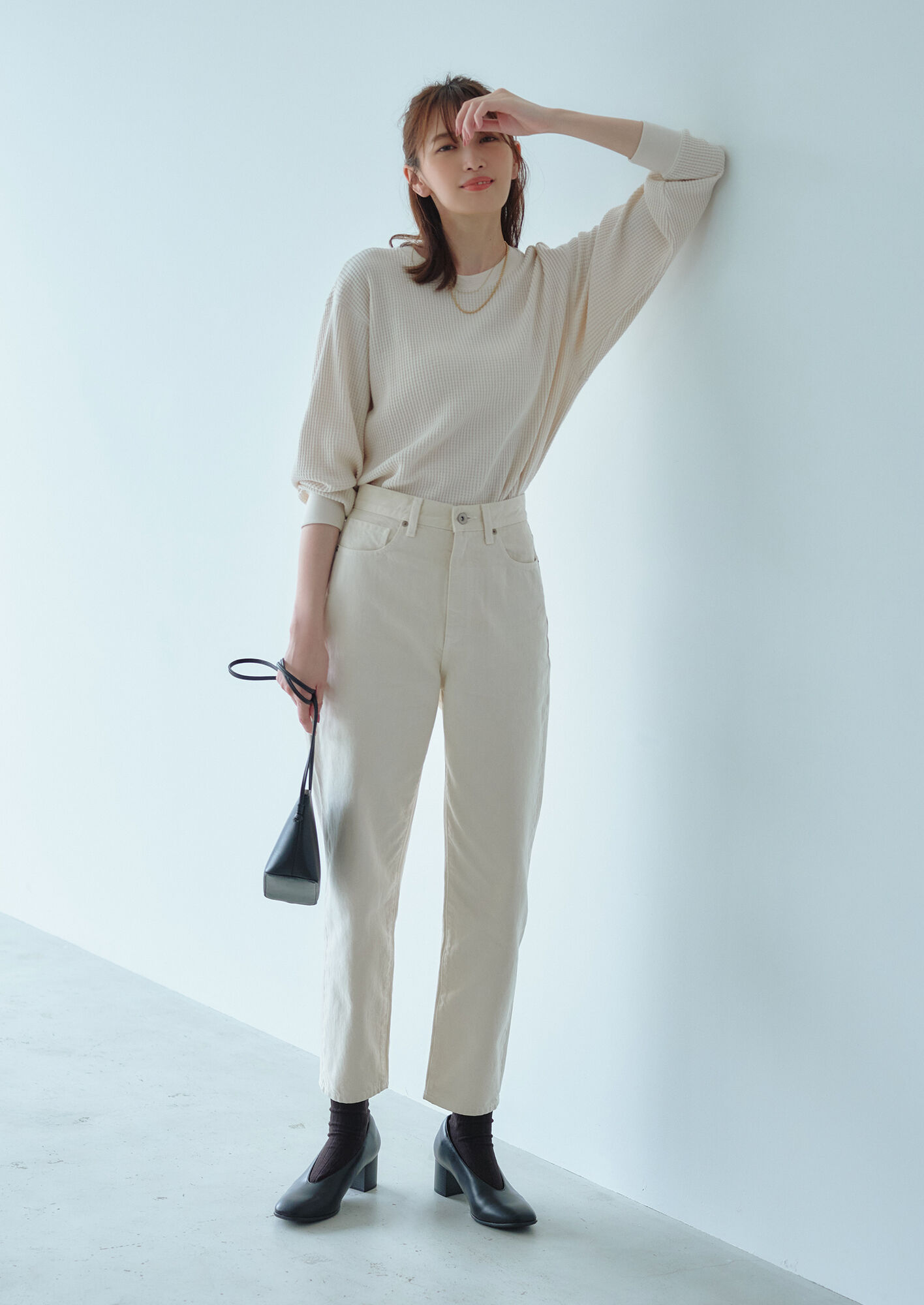 Femme portant un jean mom UNIQLO, un pull et des chaussures à talon