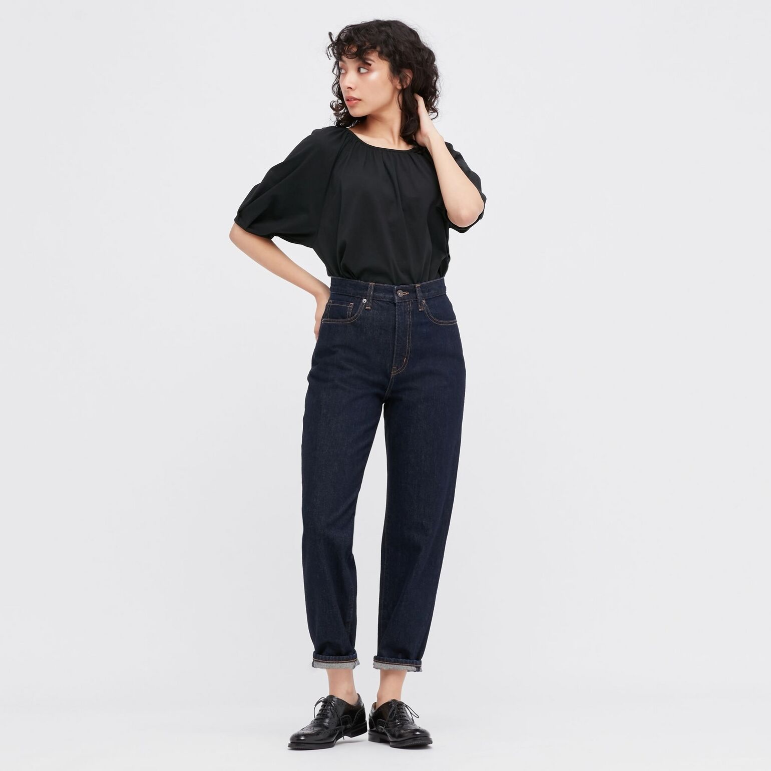 Modèle portant un jean mom femme et un t-shirt noir