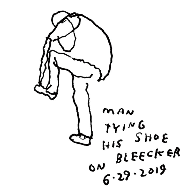 Man tying his shoe on Bleecker