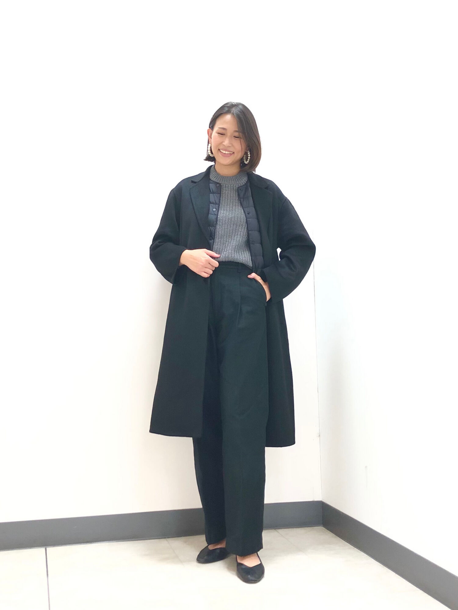 ワイドパンツに、黒のセーター、ロングコートを合わせたレディースコーデ。