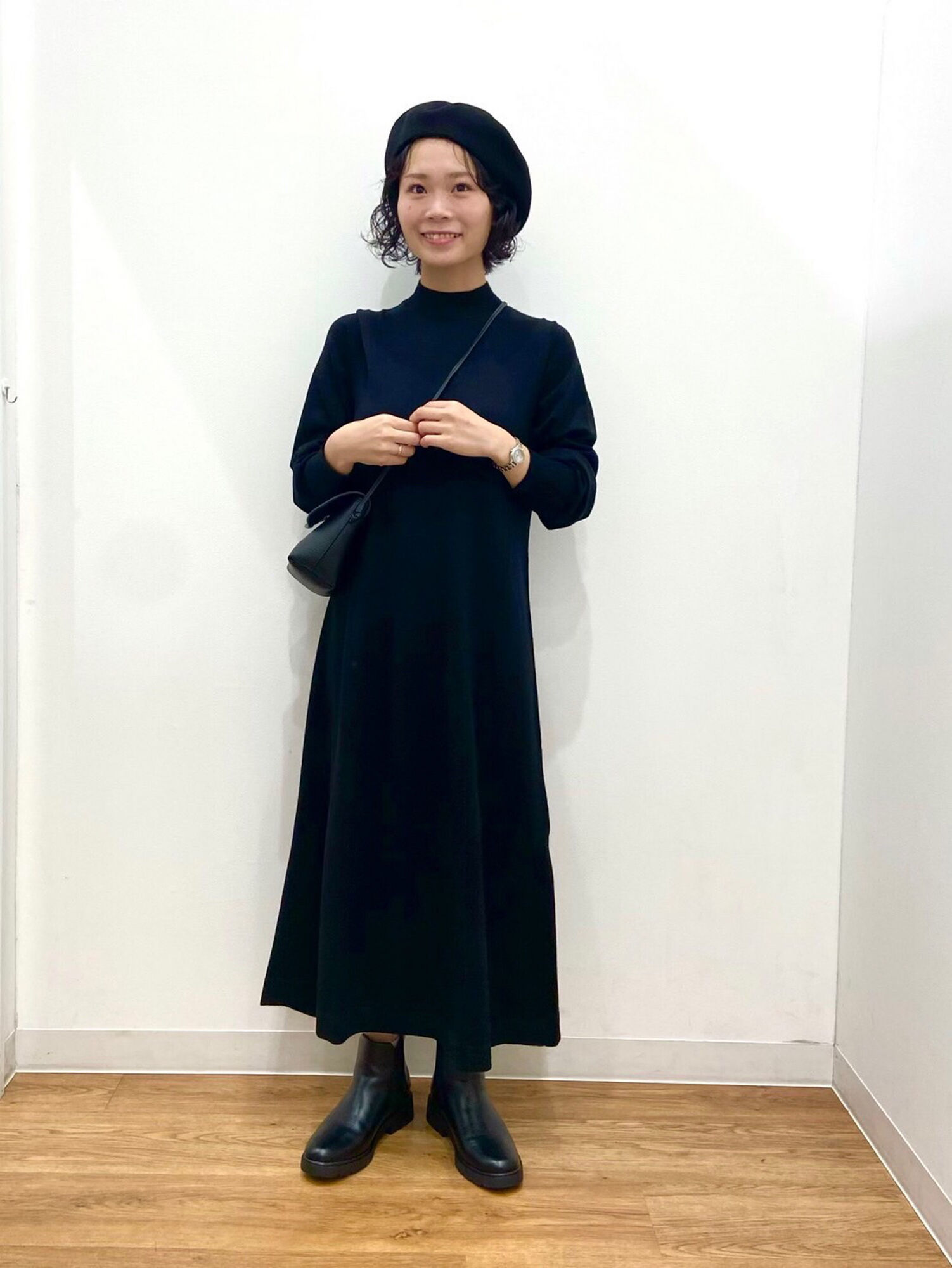 ニットワンピースにレザー調バッグやサイドゴアブーツ、ベレー帽を合わせたレディースのブラックコーデ。