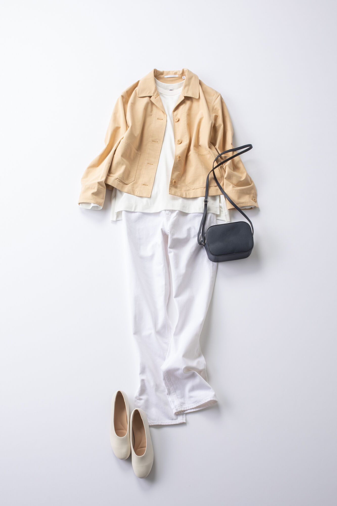 Tシャツとジーンズ、シューズを白でまとめたオールホワイトの組み合わせにベージュのジャケットをあわせたレディースコーデ。