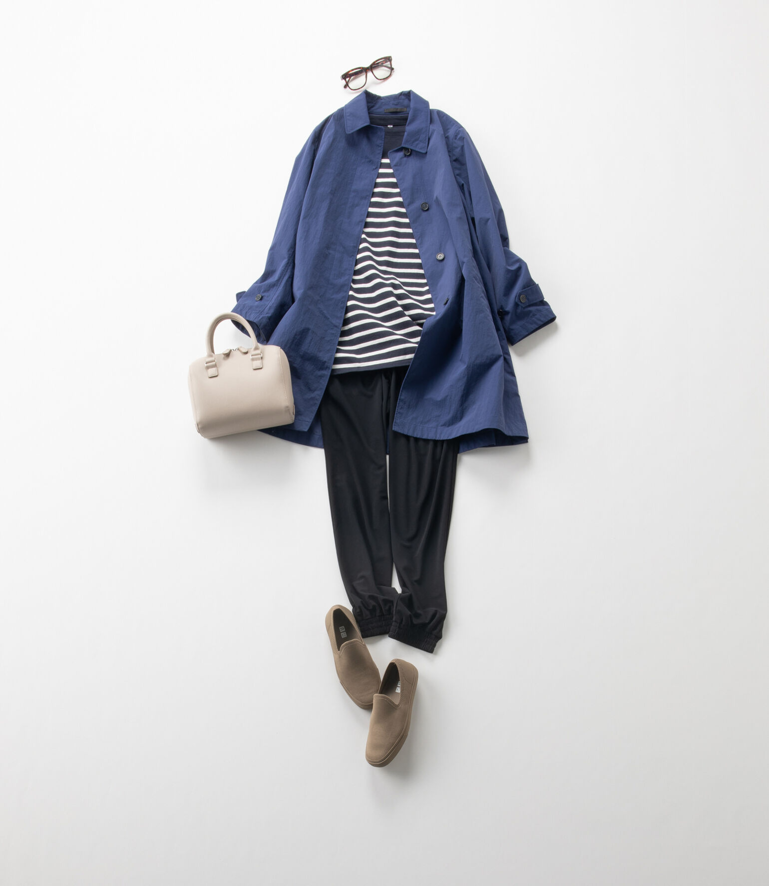 ジョガーパンツにブルーのハーフコート、レザー調のバッグを合わせたレディースのスポーツミックスコーデ。