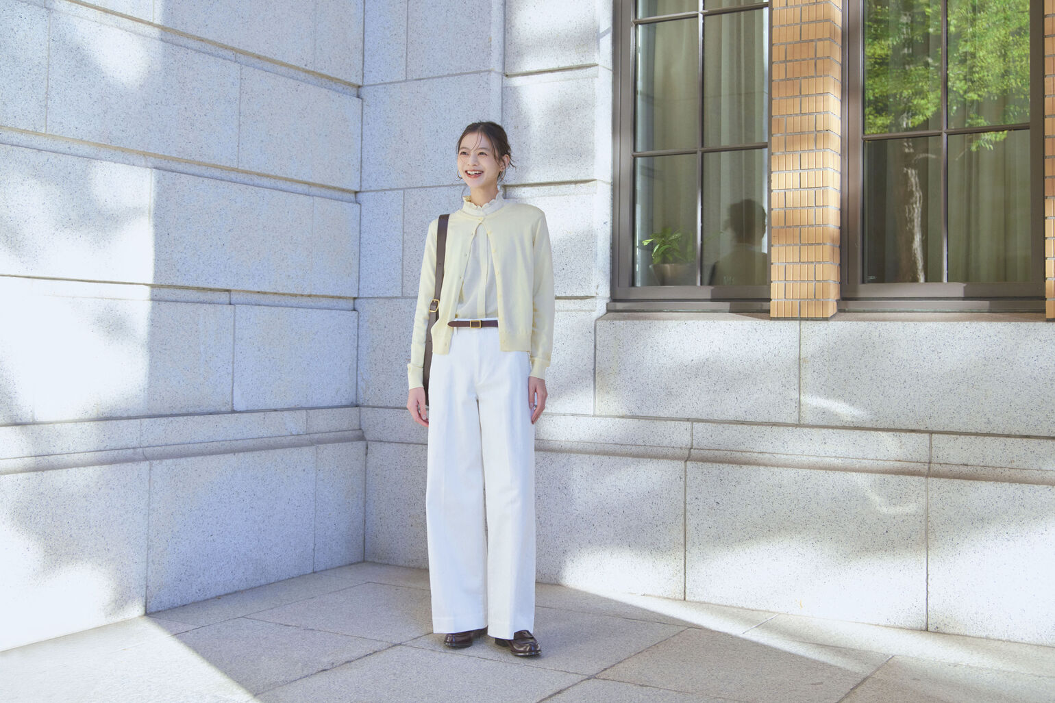 UVカットクルーネックカーディガン、フリルブラウス、ワイドトラウザージーンズを着用した女性