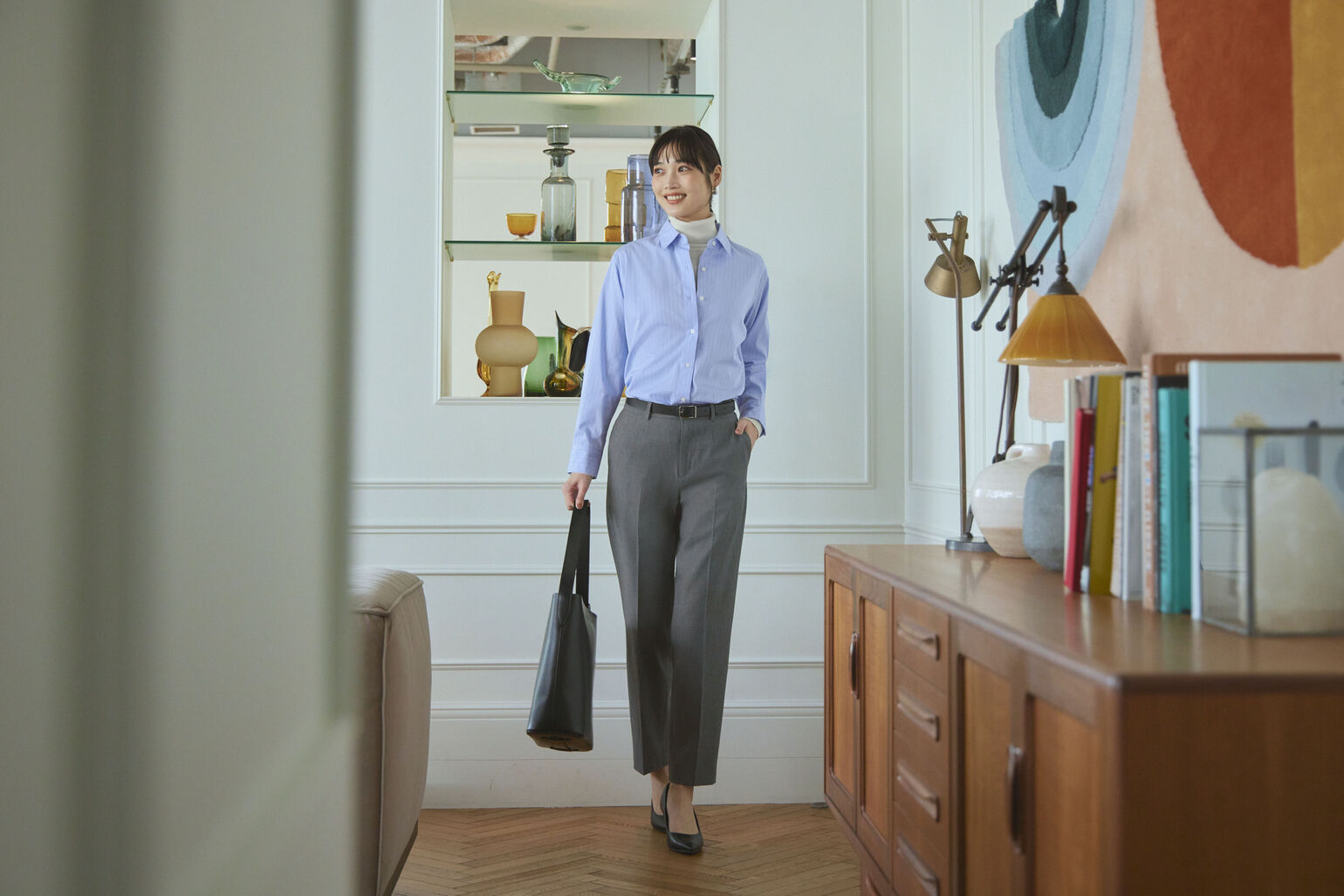 コットンシャツ、スマートアンクルパンツ、2WAYショルダーバッグを着用した女性