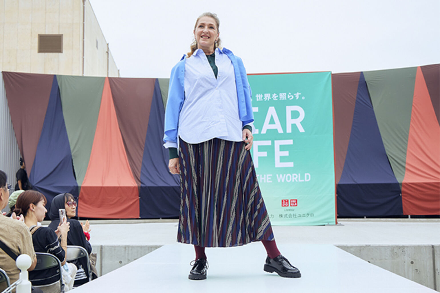 オックスフォードシャツ、コットンシャツ/ストライプ、メリノポロセーター、プリーツロングスカートを着た女性