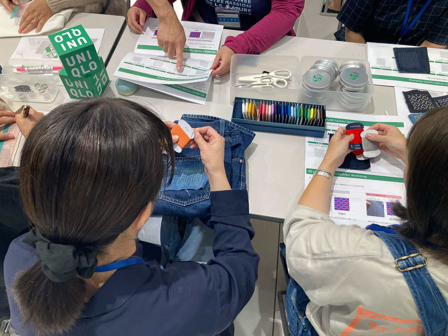 糸を手に持ち説明を聞いている画像