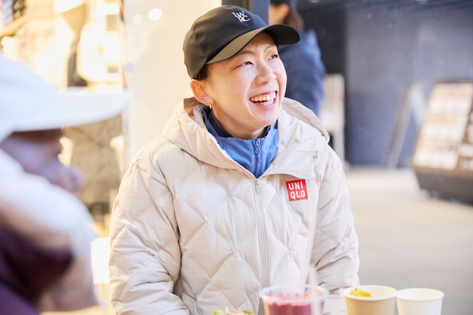 白いダウンを着た笑顔の奥本選手の画像