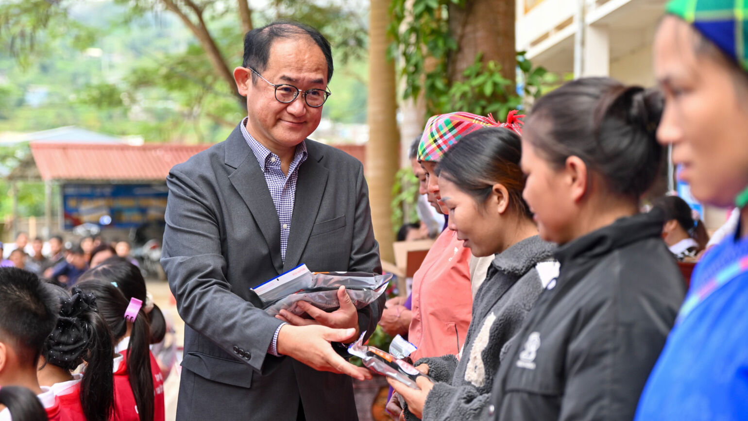 ユニクロ関係者が、笑顔で地元の女性にヒートテックを手渡している画像