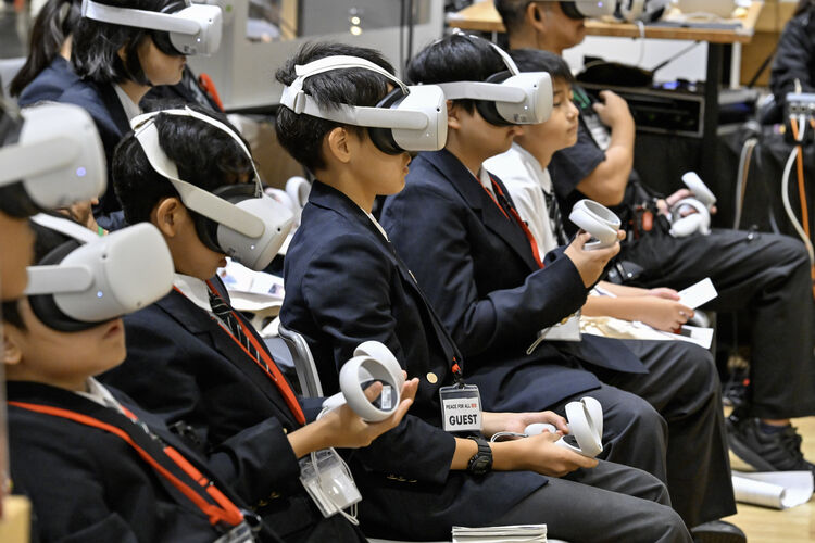 A photo of elementary and junior high school students experiencing the first VR space flight in Japan