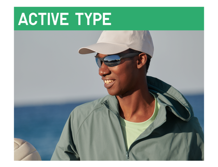 An image of a man wearing sports-type sunglasses and a white cap, smiling against a coastal background under a green 