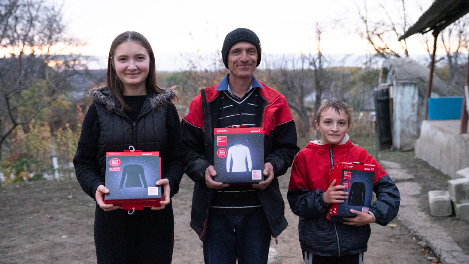 Afbeelding van een volwassene en vijf kinderen die HEATTECH-producten vasthouden en poseren voor een foto.
