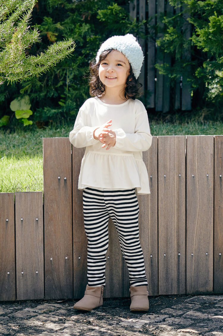 白いエアリズムコットンクルーネックTとボーダーのレギンスを着た女の子