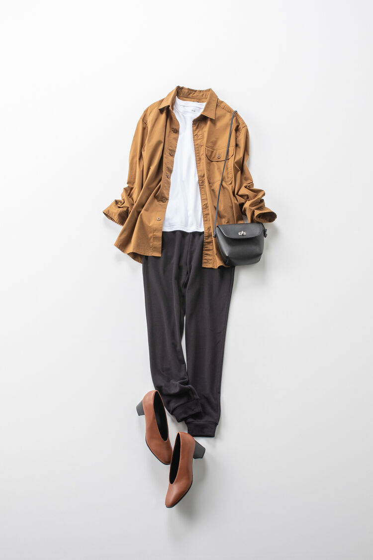 部屋着セットのパンツに白のロンT、カジュアルシャツ、パンプスを合わせたレディースコーデ