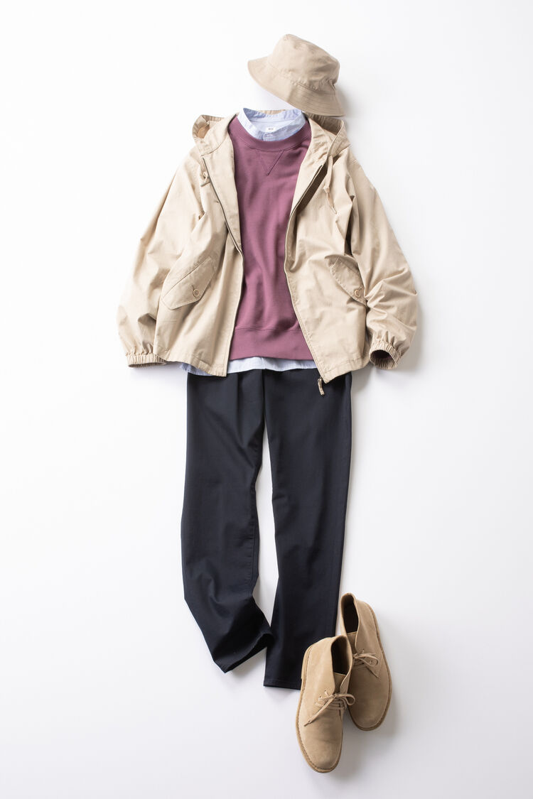 スウェットとジーンズにベージュのマウンテンパーカを羽織ったメンズコーデ。
