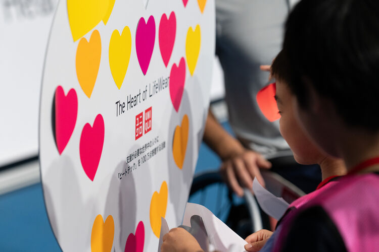 An image of a child standing in front of a heart board.