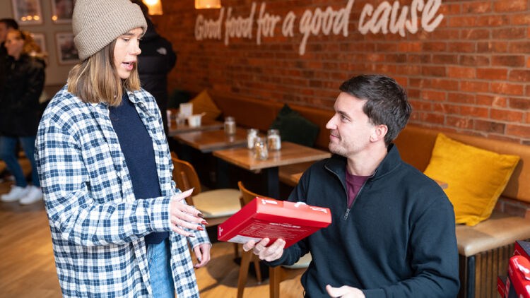 An image of Gordon Reid talking with a woman wearing a knit cap (or beanie).