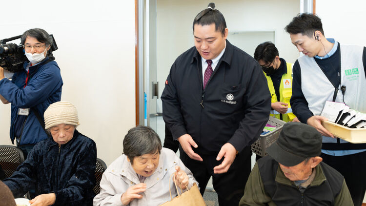 Image of a smiling woman looking at a bag containing HEATTECH products