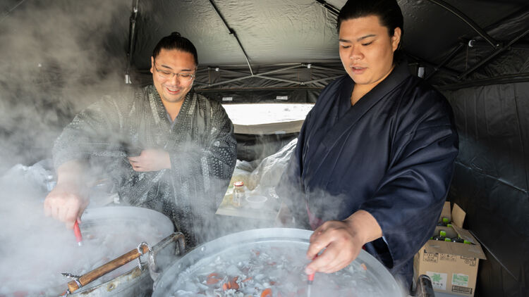 Image of two sumo wrestlers, Tochinobori and Yoshiki, cooking Chanko-nabe