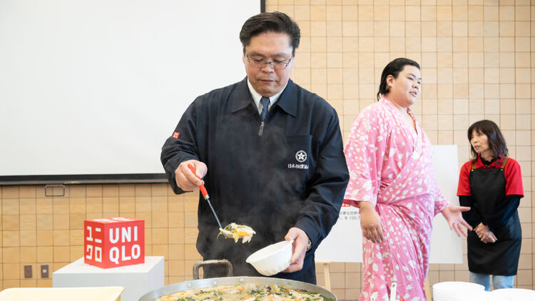 Image of Takenawa-oyakata serving Chanko-nabe into a bowl