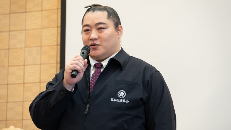 Image of Kitajin-oyakata (Sumo Master Kitajin) speaking with a microphone