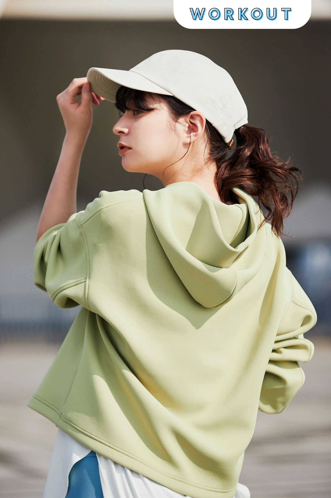 黄緑のウルトラストレッチドライスウェットプルパーカに白いキャップの女性上半身