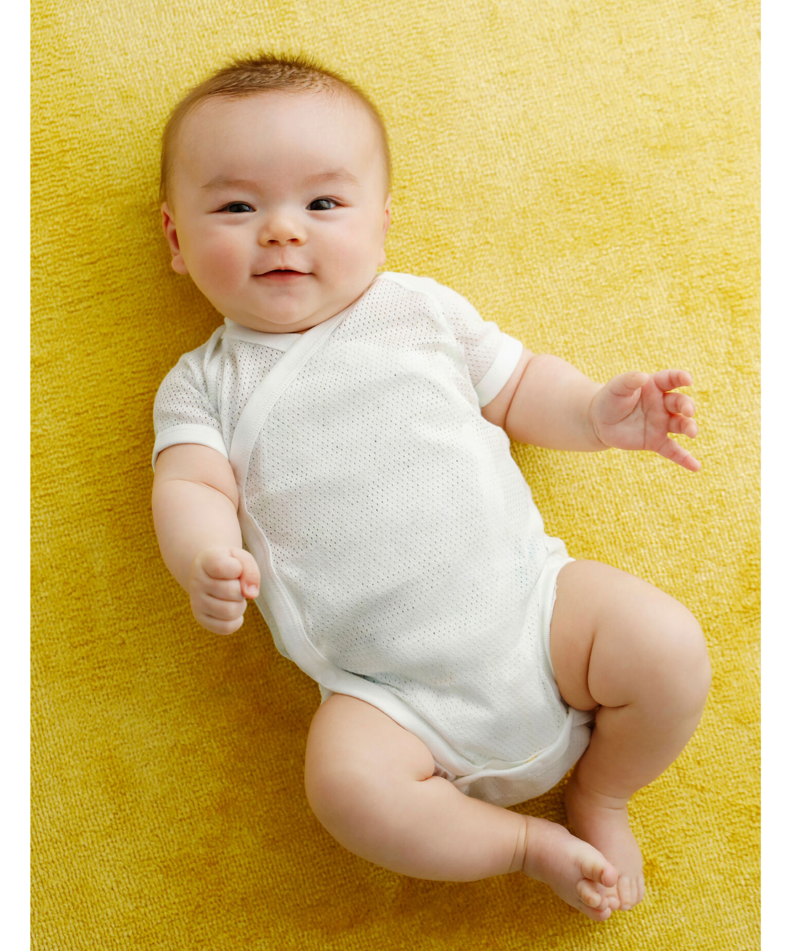 白いボディスーツを着た赤ちゃん
