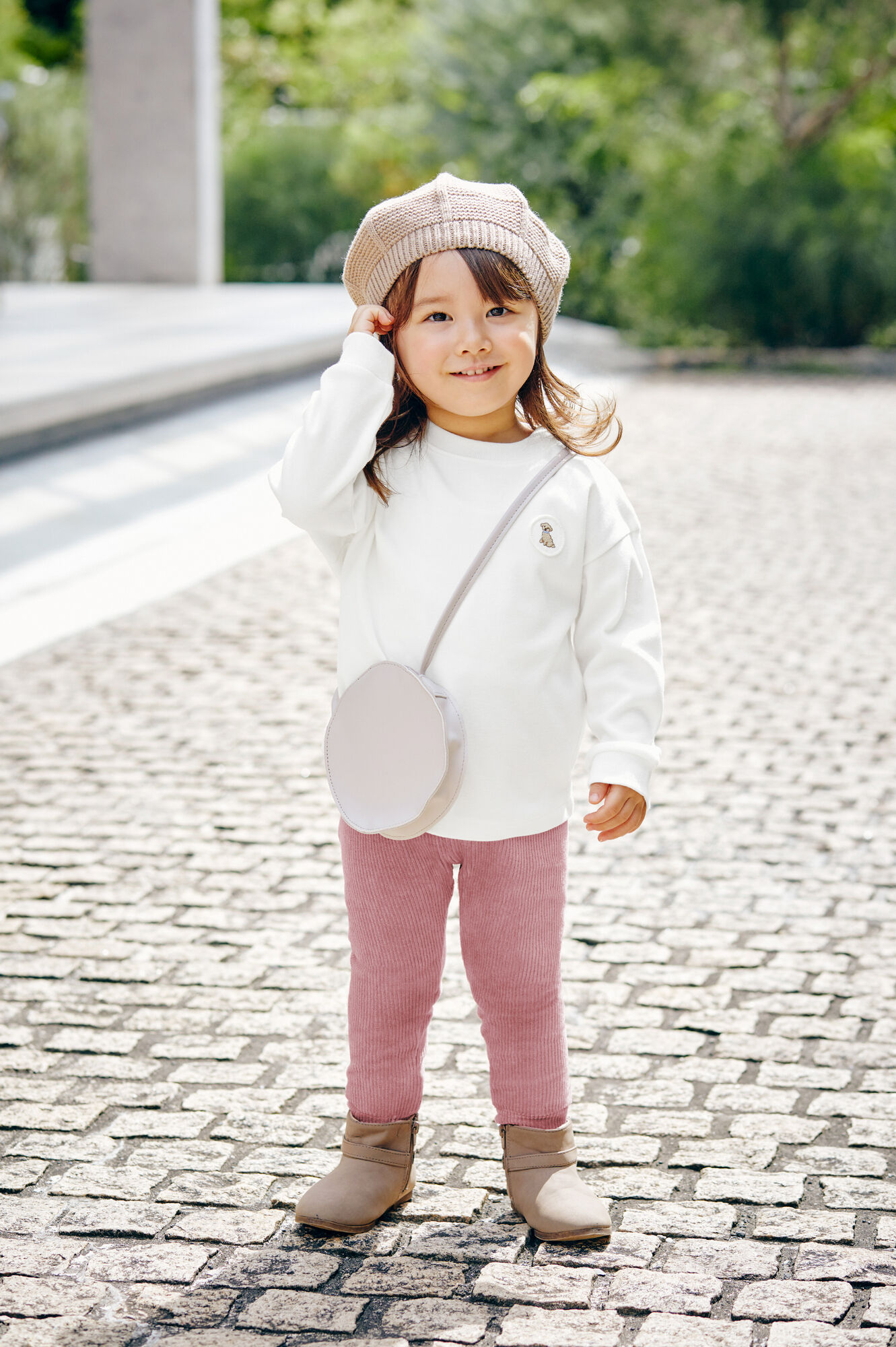 白いソフトタッチコットンクルーTとピンクのレギンスを着た女の子