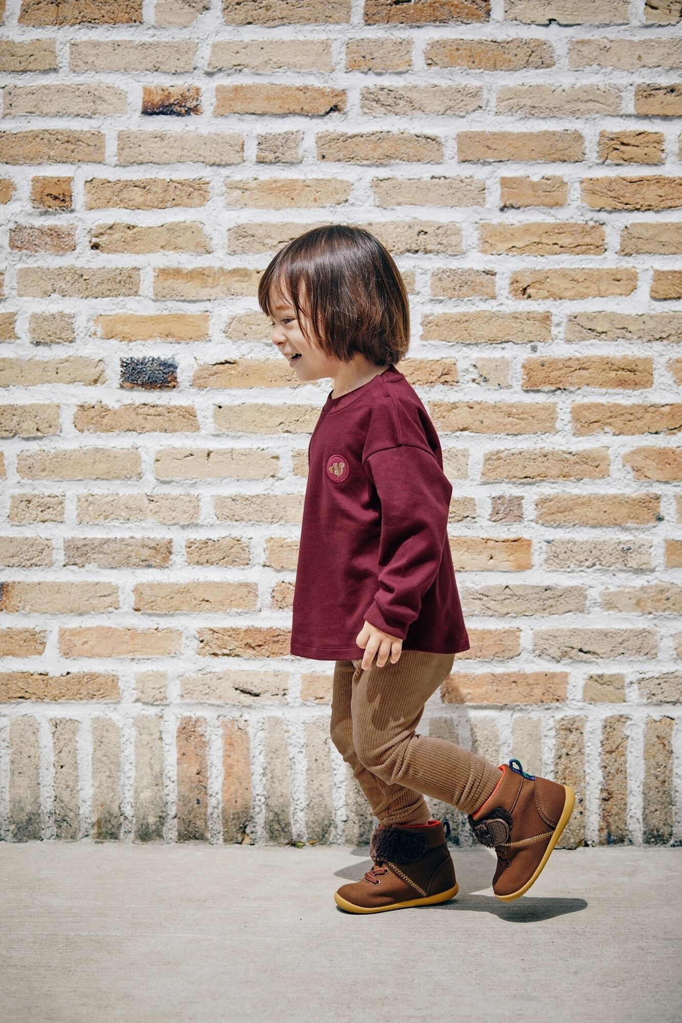 ワイン色のソフトタッチコットンクルーTとブラウンのレギンスを着た男の子