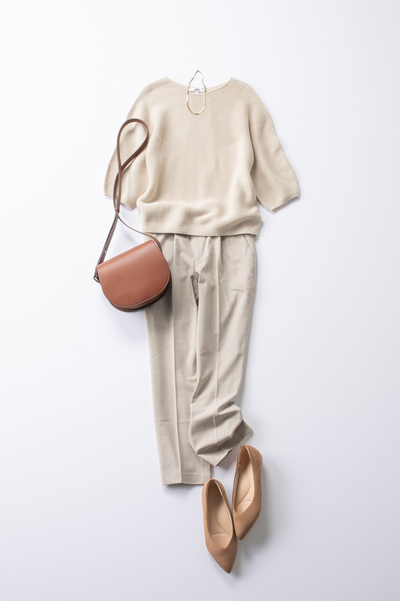 ベージュのセーターにベージュのパンツを合わせたレディースコーデ。