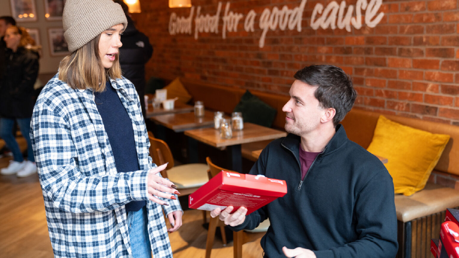 An image of Gordon Reid talking with a woman wearing a knit cap (or beanie).