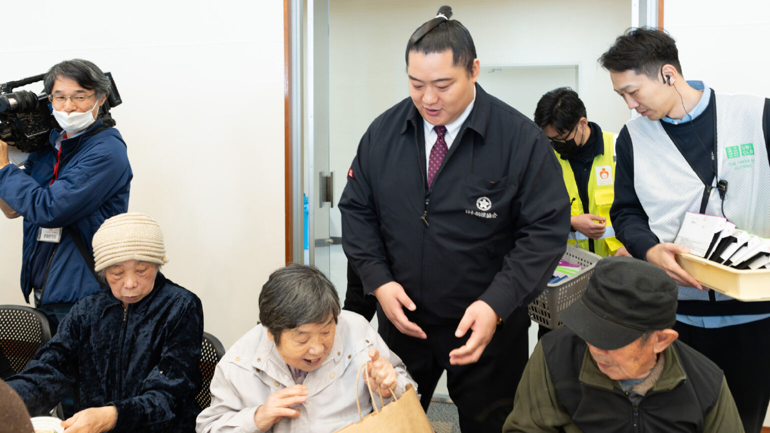 Image of a smiling woman looking at a bag containing HEATTECH products
