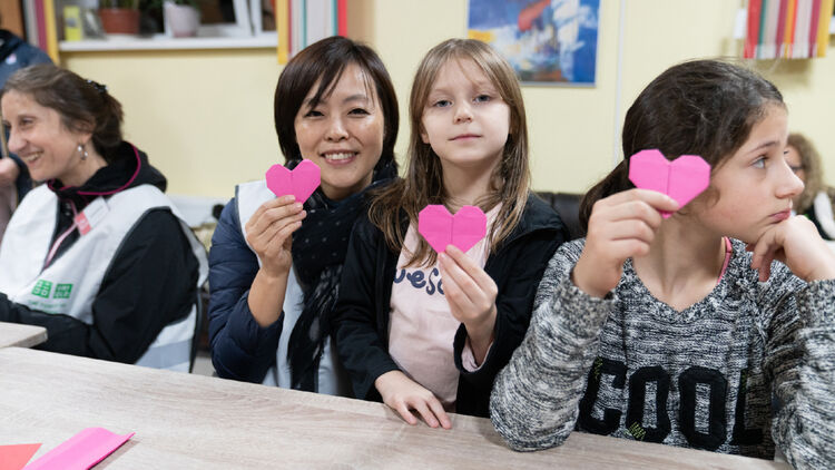 Image of a woman posing with a heart-shaped message card