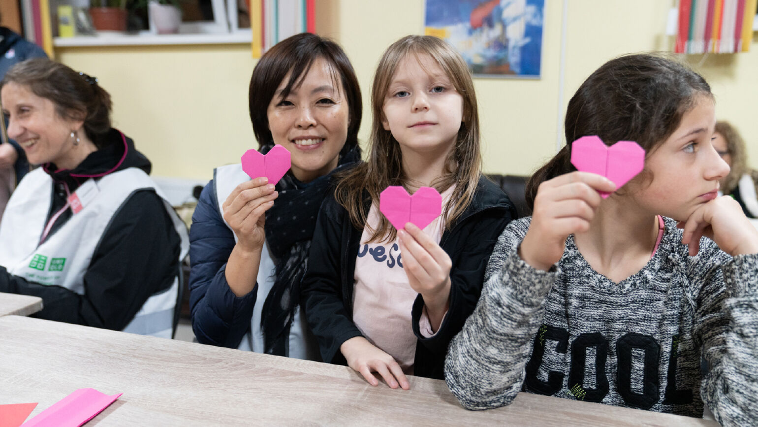 Image of a woman posing with a heart-shaped message card