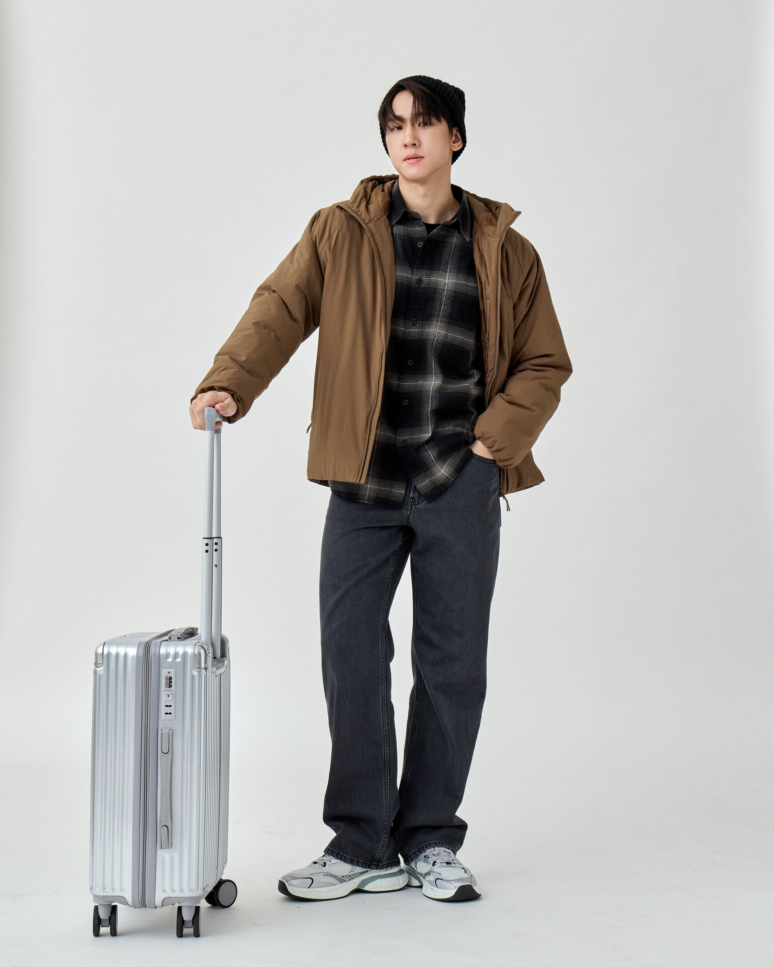 ผู้ชายสวมชุดกันหนาวพร้อมกระเป๋าเดินทางเพื่อเดินทางท่องเที่ยวระหว่างเมือง